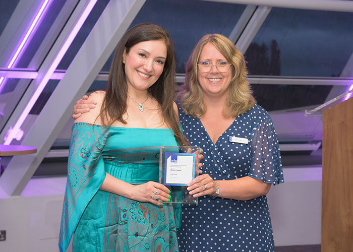Karen Barker, Director of Stakeholder Engagement, presenting Elham Fardad, the Founder of Migrant Leaders,with her Alumni award.