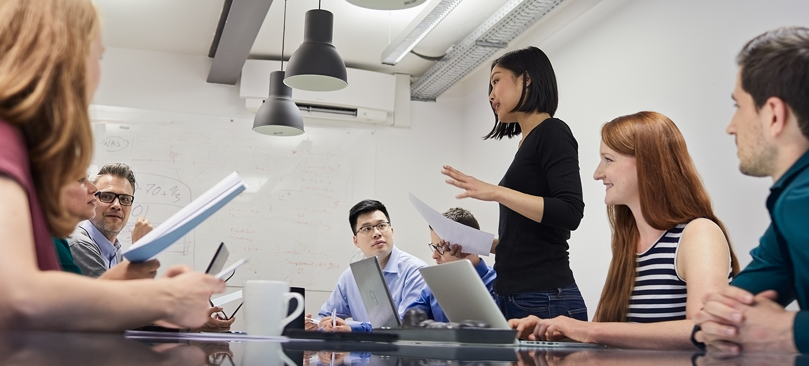 A team of employees discuss strategy during a business meeting A team of employees discuss strategy during a business meeting