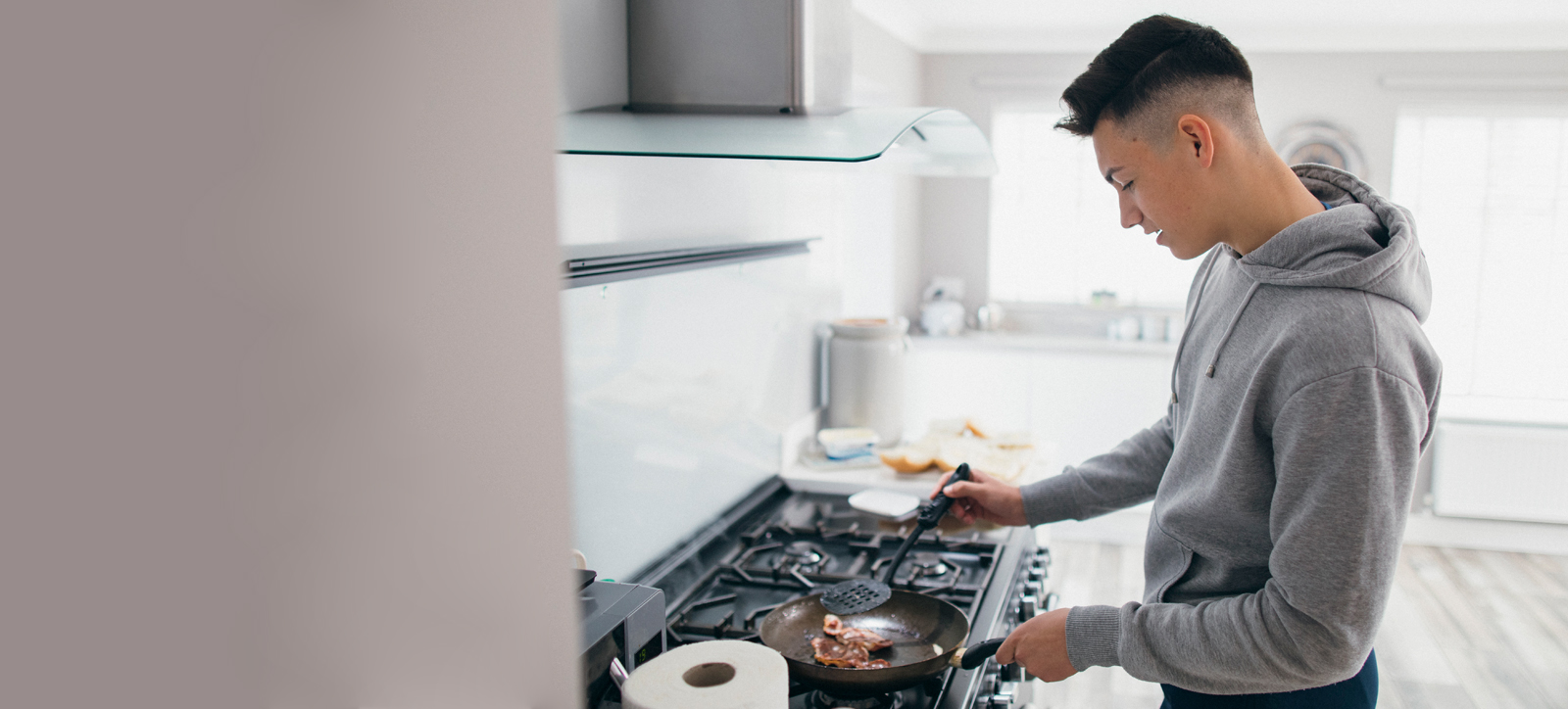 A teenage care leaver cooks for themselves in their own accommodation. A teenage care leaver cooks for themselves in their own accommodation.