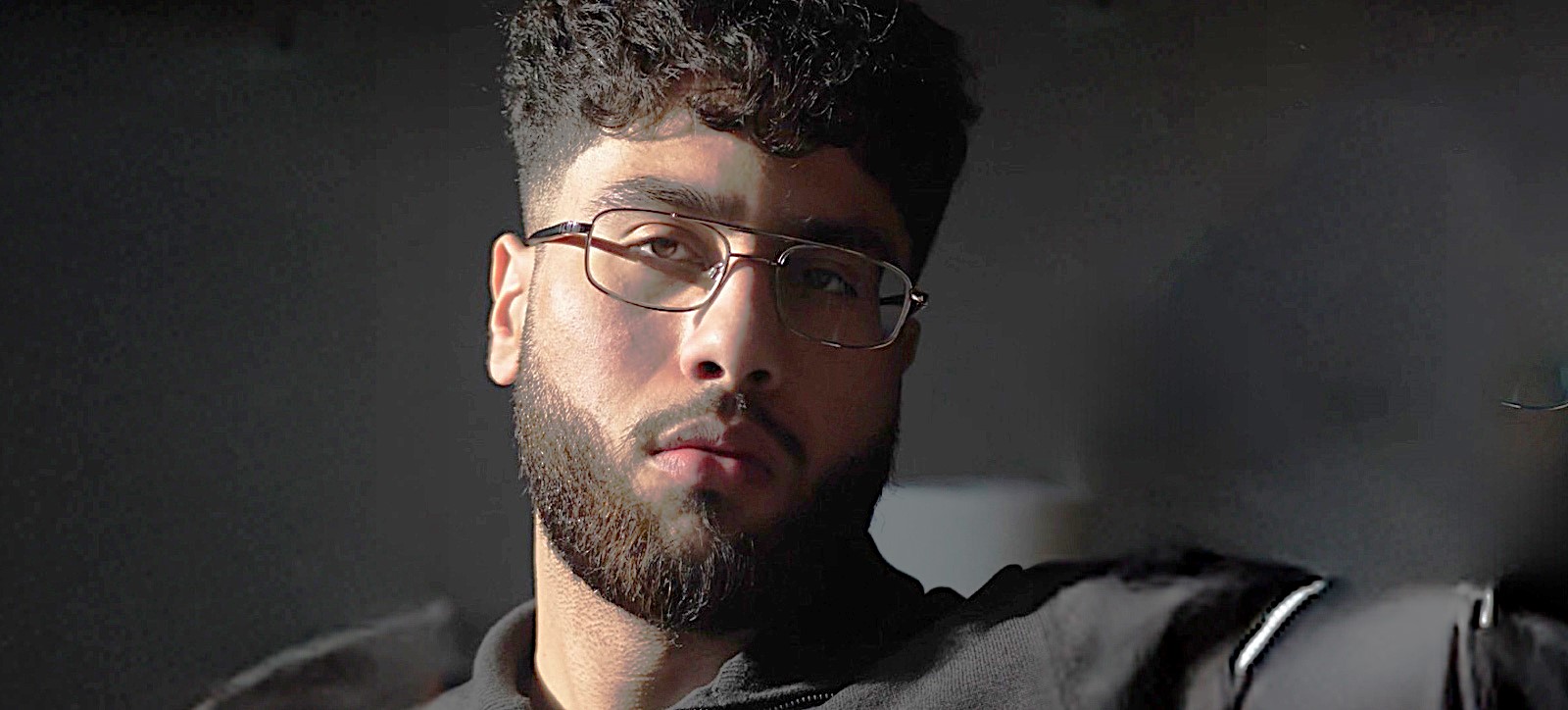 Ibrahim Malik in black and with a closely shaved beard Ibrahim Malik in black and with a closely shaved beard