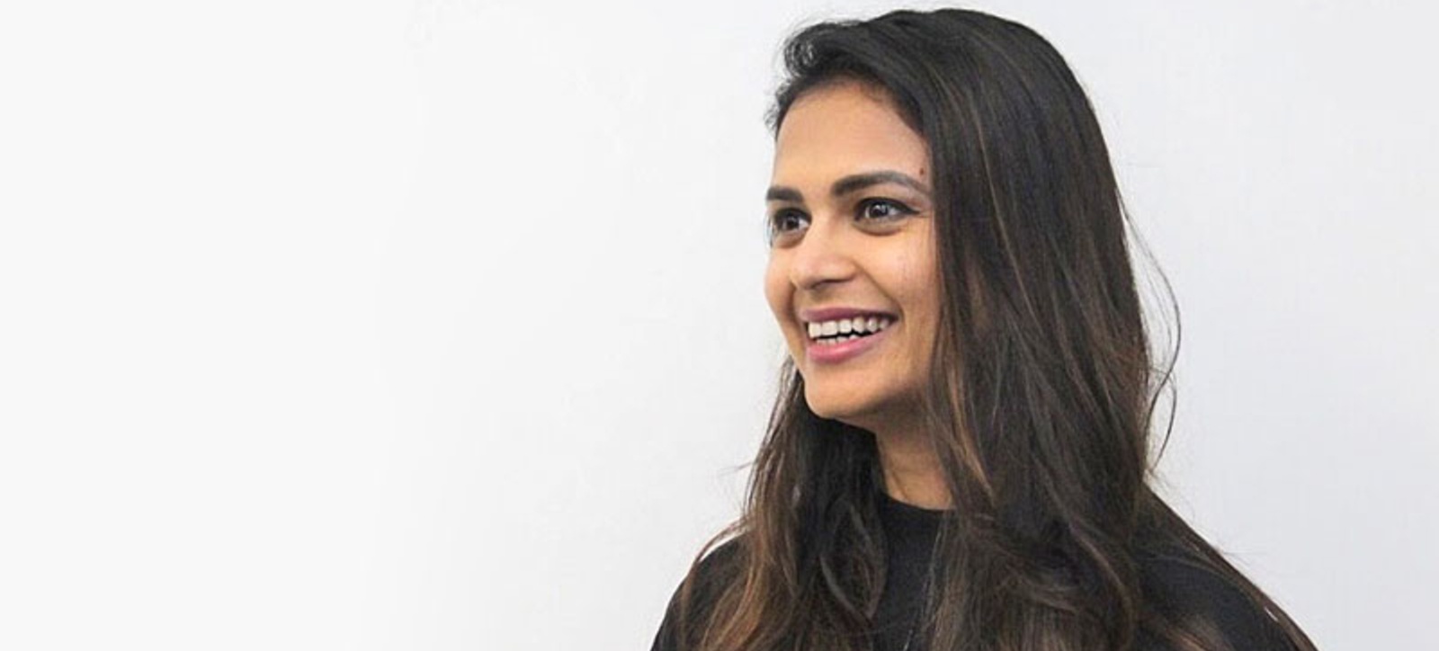 Gauri Agrawal dressed in black and smiling at something off camera. Gauri Agrawal dressed in black and smiling at something off camera.
